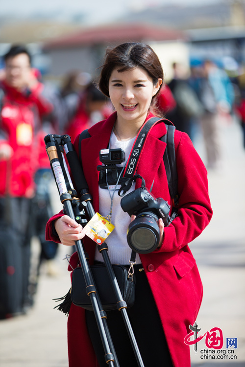 2016年兩會，人民大會大堂前，一位笑容燦爛的紅衣女記者正步入大會堂。中國網(wǎng) 鄭亮 攝