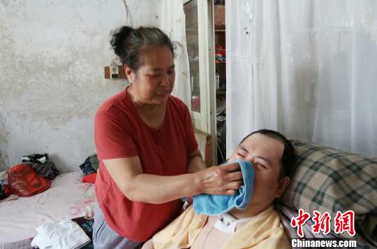 每次喂完食物后，梁青蘭都要仔細地幫兒子清理干凈?！∩忻鱾b 攝