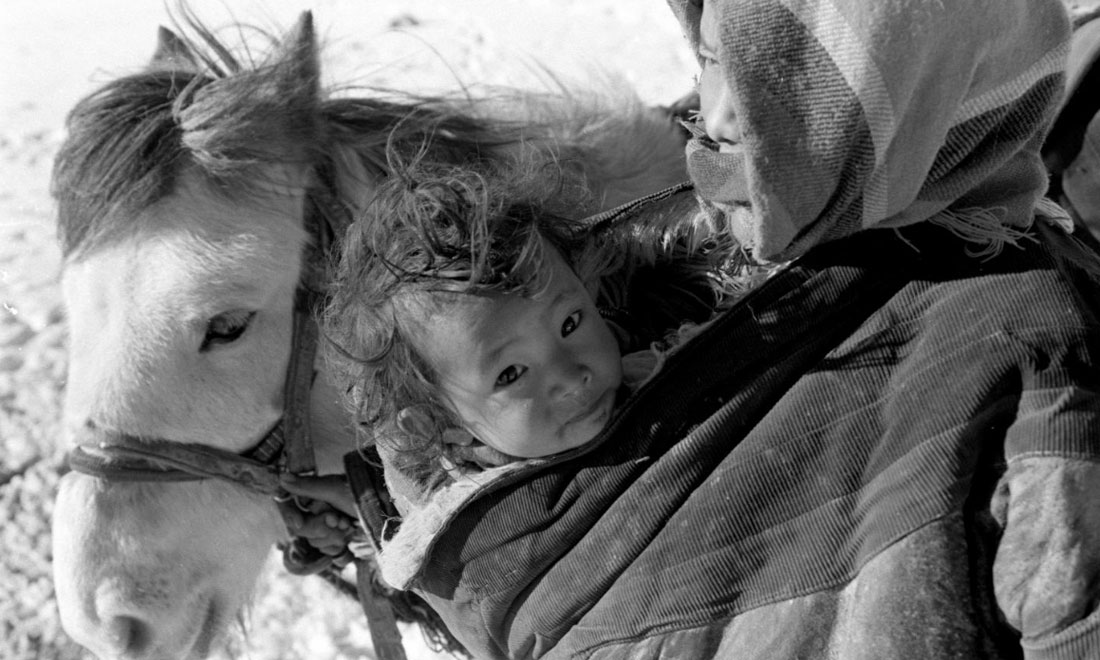 1990年3月，西藏當(dāng)雄縣納木湖鄉(xiāng)三村女牧民斯卓不畏嚴(yán)寒，懷抱幼子，準(zhǔn)備到遠(yuǎn)處放牧。新華社記者覺(jué)果攝